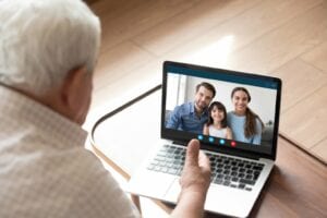 A senior talking to his family via laptop videoconference call at home during the COVID-19 coronavirus pandemic